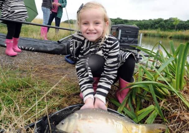 At Kippax Park Fishery, Leeds, McKenzi Whittaker, 5, with a carp