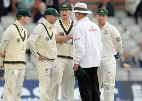 Australia's Michael Clarke talk with umpire Tony Hill as rain stops play