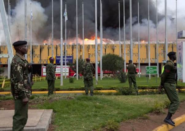 Policemen stand guard as fire engulf the international arrivals unit of Jomo Kenyatta International Airport, Nairobi, Kenya
