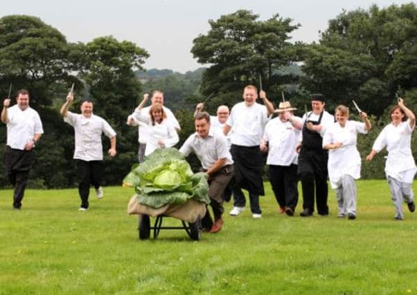 Show director, Martin Fish is chased by ten chefs as he wheels a giant cabbage at the Harrogate Autumn Flower Show in North Yorkshire. PIC: PA