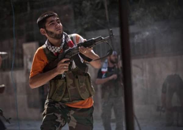 A Free Syrian Army soldier fires his machine gun against Syrian Army positions in the Izaa district of Aleppo