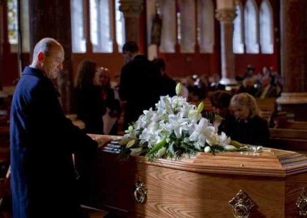 A mourners lays his hands on the coffin of Nobel Laureate poet Seamus Heaney
