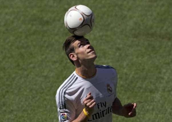 Welsh international soccer player Gareth Bale bounces a ball on his head during his official presentation at the Santiago Bernabeu stadium  in Madrid