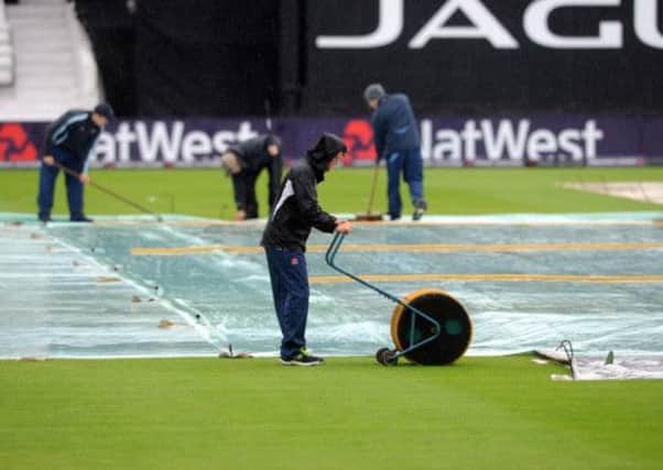Headingley groundstaff mop the pitch as the rain falls delaying the start of England one day international match with Australia