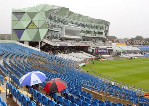 Hardy fans wait for play under umbrellas as rain falls delays the start of England one day international match with Australia at Headingley.