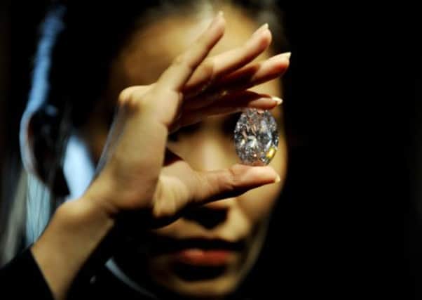 A Sotheby's employee holds the white diamond at 118.28 carats