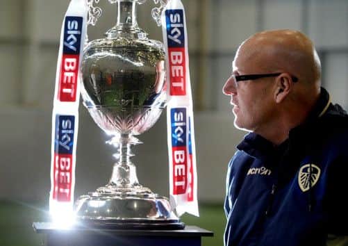 Brian McDermott admires the Championship trophy.