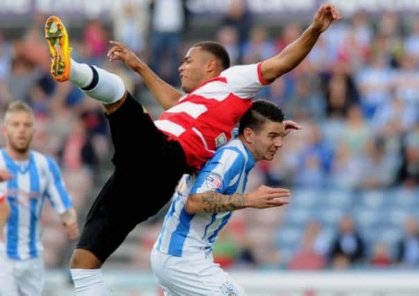Reece Wabara is challenged by Huddersfield player Adam Hammil