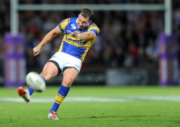 OVER YOU GO: Danny McGuire kicks the crucial drop goal which saw Leeds Rhinos through. Picture: Steve Riding.