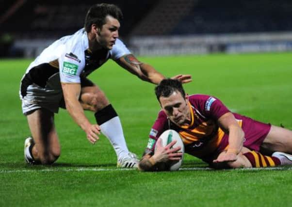 DON'T STOP ME NOW: Huddersfield Giants' Shaun Lunt scores a try under pressure from Hull FC's Tom Briscoe.