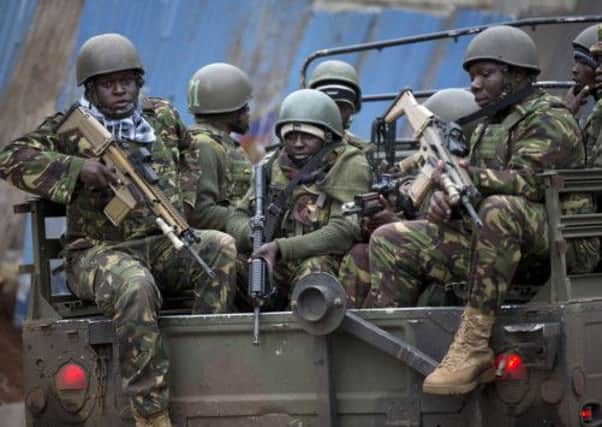 Trucks of soldiers from the Kenya Defense Forces arrive after dawn outside the Westgate Mall in Nairobi, Kenya