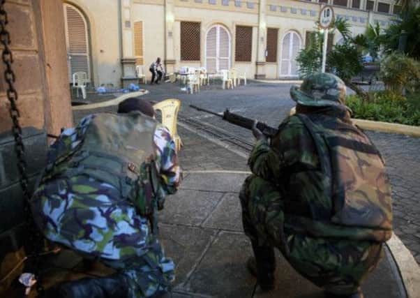 Kenya security personnel take cover outside the Westgate Mall