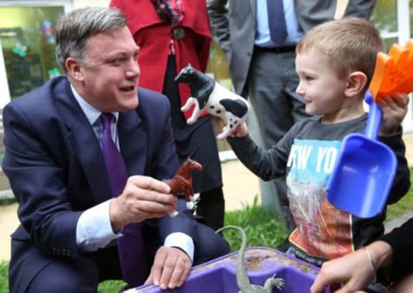 Shadow Chancellor Ed Balls plays with three year old Connor Felton at the Roundabout Children's Centre in Brighton
