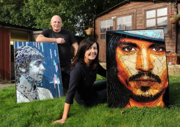 Mosaic artists Allan Butt and Rita Gav with portraits of Paul McCartney and Johnny Depp