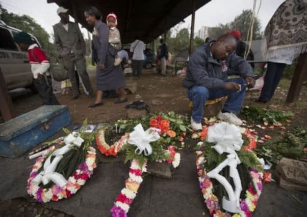 A street-seller makes floral wreaths outside the mortuary in Nairobi