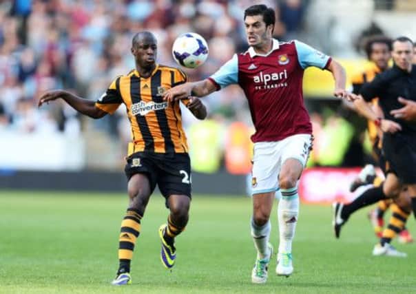 Hull City's Sone Aluko and West Ham United's James Tomkins (right) during the Barclays Premier League match at the KC Stadium, Hull.