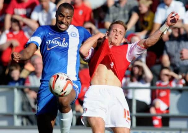 Rob Milsom battles for the ball with Peterborough player Tyrone Barnett