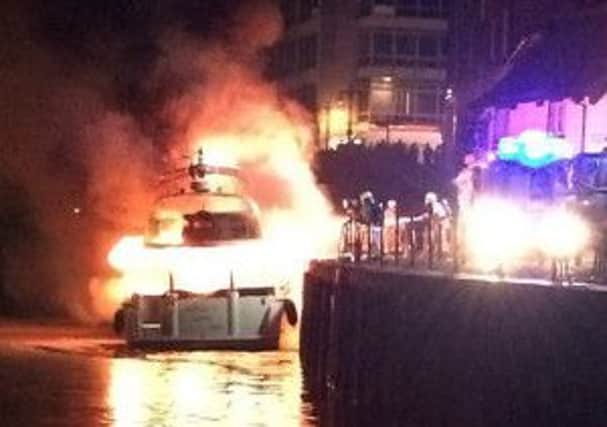 The  boat on fire on the River Ouse  as firemen try to extinguish the flames