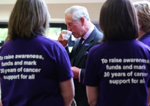 The Prince of Wales speaks with volunteers during a tour of CLAN Cancer Support