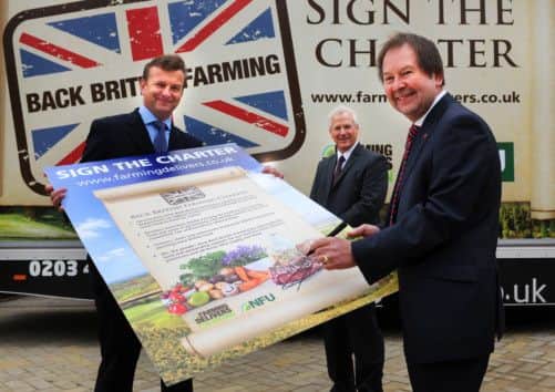 Morrisons Corporate Services Director Martyn Jones, right, signs the NFU Back British Farming Charter with NFU Regional Director Richard Pearson, left, and Head of Agriculture at Morrisons David Evans
