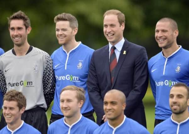 The Duke of Cambridge stands with members of the Polytechnic FC prior to their match against the Civil Service FC, in the grounds of Buckingham Palace