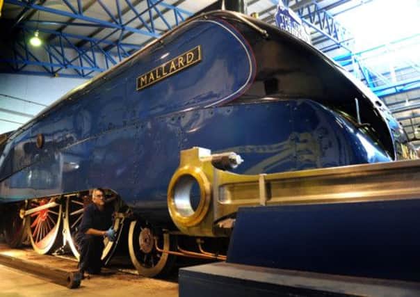Dave Leyshon, a mechanical engineer at the National Railway Museum, on the  connecting rods waiting to be attached to the wheels of Mallard