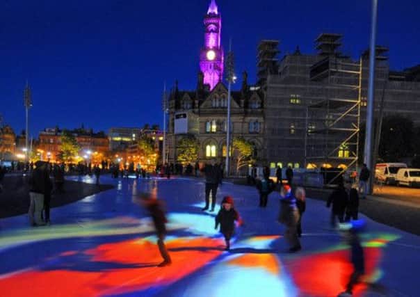 Children play on the art installation 'A Mirrored Pool of Thought' projected onto Bradford's City Park
