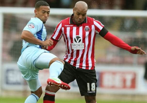 Jordan Clarke of Coventry City challenges for the ball with Marlon King of Sheffield United