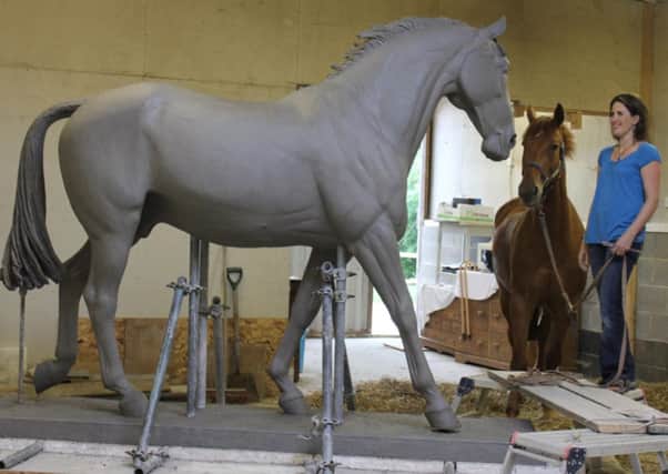 Artist Camilla Le May with ED the horse as they look at  her sculpture of Sefton, at her studio in East Sussex.