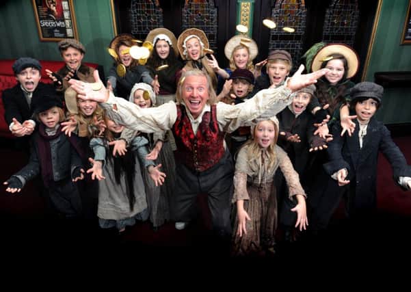 Tommy Steele with local children appearining in Scrooge The Musical The Grand Theatre in Leeds.