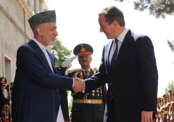 David Cameron is greeted by Afghan President Hamid Karzai in Kabul