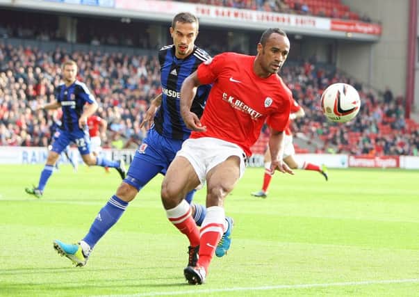 BARNSLEY'S CHRISO'GRADY HOLDS OFF THE CHALLENGE FROM SEB HINES.