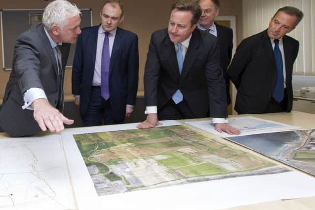 Nigel Cann site director of Hinkley Point C, Energy Secretary  Ed Davey, Prime Minister David Cameron, Vincent de Rivaz, Chief Executive of EDF (Electricite de France) and Henri Proglio, CEO and Chairman of EDF examine site plans for the news Hinkly C nuclear power station at Hinkley Point, Somerset.