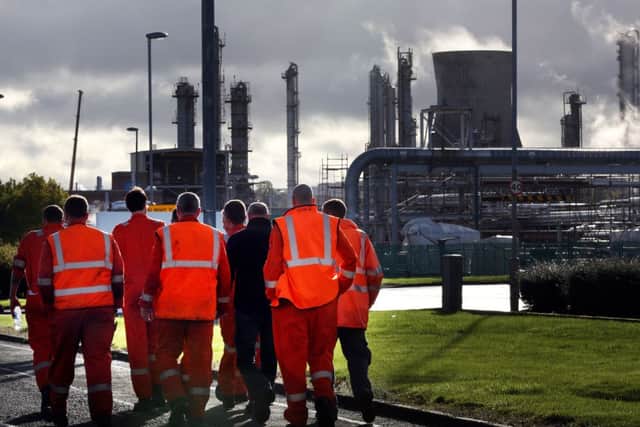 Workers walk through the Grangemouth oil refinery in Falkirk