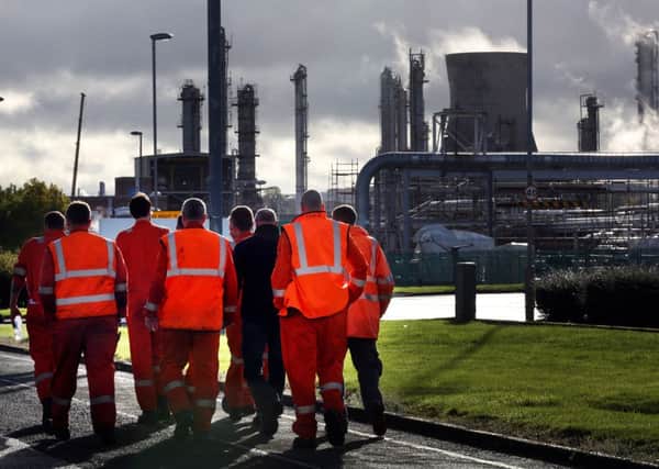Workers walk through the Grangemouth oil refinery in Falkirk