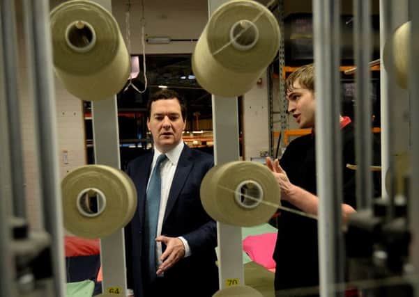 Chancellor George Osborne speaks with management trainee Robert Taylor during a visit to AW Hainsworth and Sons in Leeds