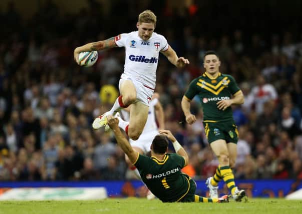 England's Sam Tomkins (top) jumps over a challenge from Australia's Billy Slater.