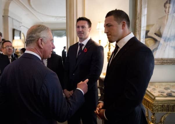 The Prince of Wales, speaks with England national rugby league player Sam Burgess (right), during a reception for the Rugby League World Cup at Clarence House in London.