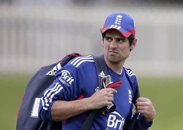 England's captain Alastair Cook looks around the field as he prepares to go off as light rain begins to fall just before the start of the third day of their cricket tour match against Australia A in Hobart. (AP Photo/Rick Rycroft)