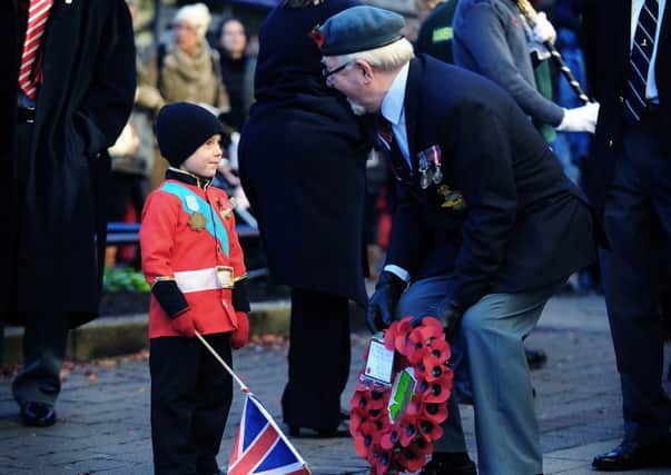 Four-year-old Finlay Monteith chats to vetern Dennis Marshall before the start of the Remembrance Day Service parade through Morley, Leeds.