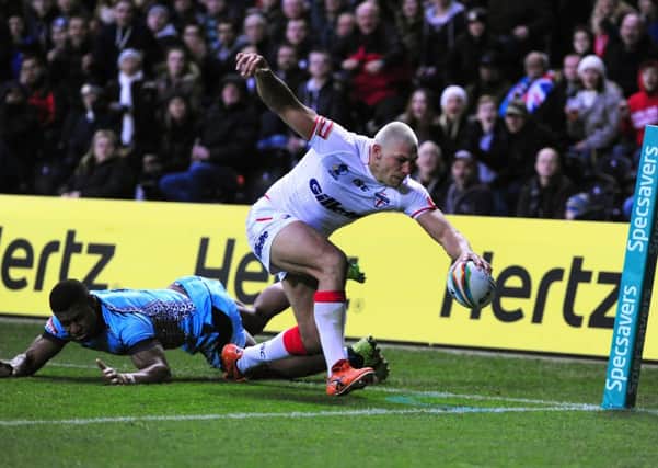 England's Ryan Hall reaches over to score a try under pressure from Fiji's Kevin Naiqama
