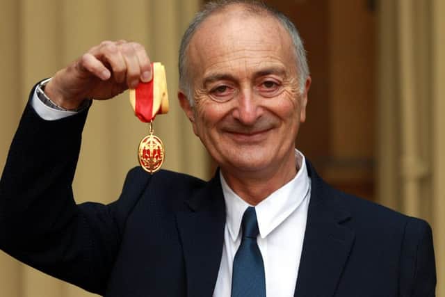 Sir Tony Robinson holds his medal after being knighted by the Duke of Cambridge at Buckingham Palace