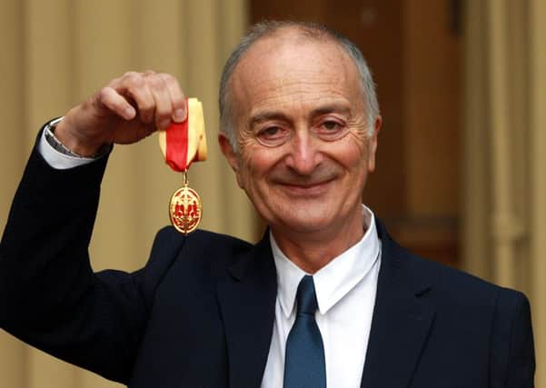 Sir Tony Robinson holds his medal after being knighted by the Duke of Cambridge at Buckingham Palace
