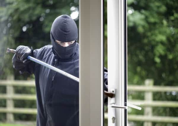 A burglar breaking into a house.