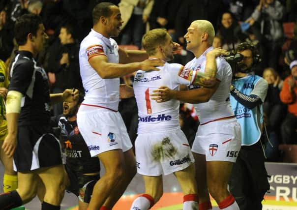 Ryan Hall celebrates his first try with Sam Tomkins and Leroy Cudjoe