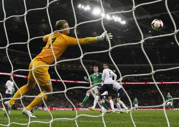 Germany's Per Mertesacker, centre, scores pass England's goalkeeper Joe Hart.