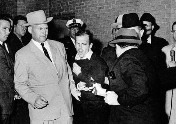 Lee Harvey Oswald, suspected assassin of President Kennedy, grimaces as he is shot to death at point-blank range by nightclub owner Jack Ruby