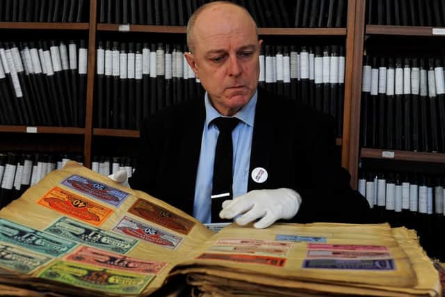 Archivist Dr Charles Kelham looks at a collection of 19th century race tickets from Doncaster Racecourse.
