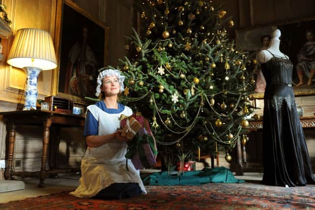 Mollie Dodd, General Manager of Nunnington Hall, dressed as a maid by the tree in the Oak Hall