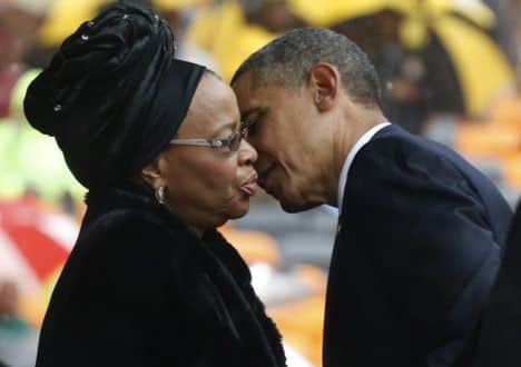 President Barrack Obama kisses Nelson Mandela's widow Graca Machel during the memorial service for former South African president Nelson Mandela